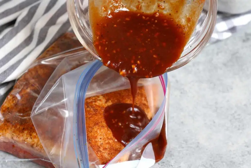 Versare la salsa barbecue sul petto in una sacca con ziptop.