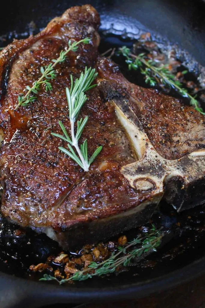Bistecca di costole in fiamme in una padella calda.