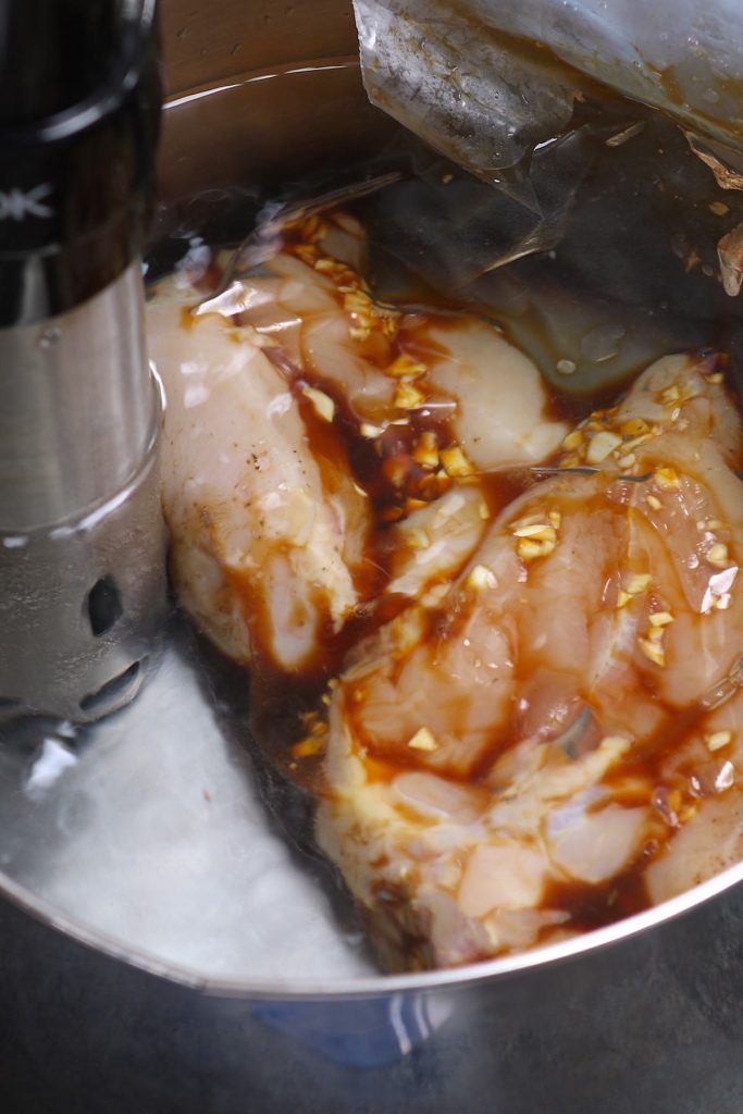 Cuocere i petti di pollo nel vuoto in un bagno d'acqua sotto vuoto.