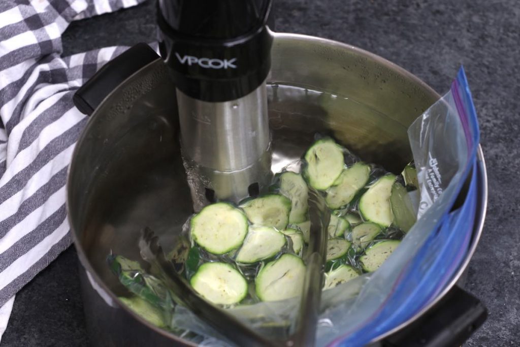 Cucinare le fette di zucchine nel bagno d'acqua sotto vuoto.
