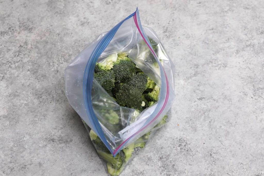 Aggiungi i fiori di broccoli e condisci in una borsa.