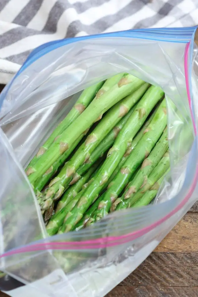 Irrorare l'olio d'oliva sugli asparagi in un sacchetto ben sigillato.